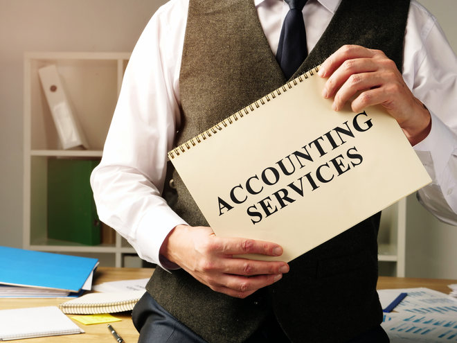 a man holding a notebook with a sign of Accounting Services